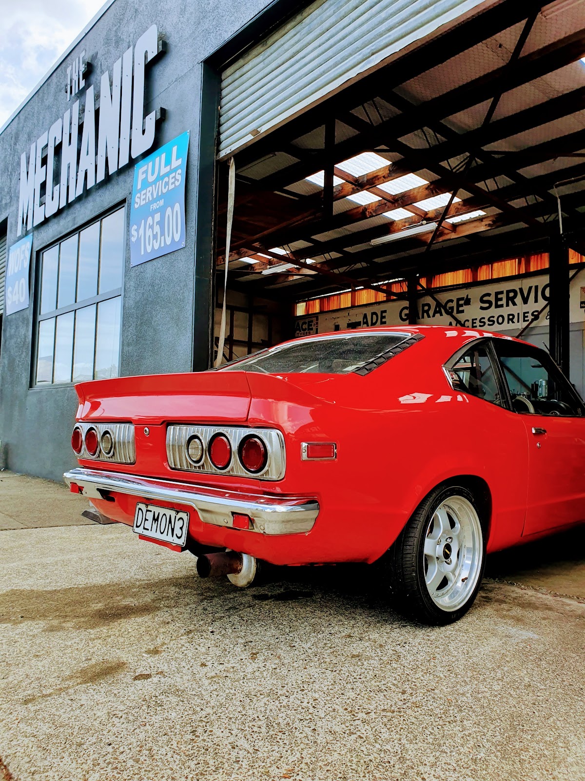 Red Mazda RX-3 coupe outside The Mechanic