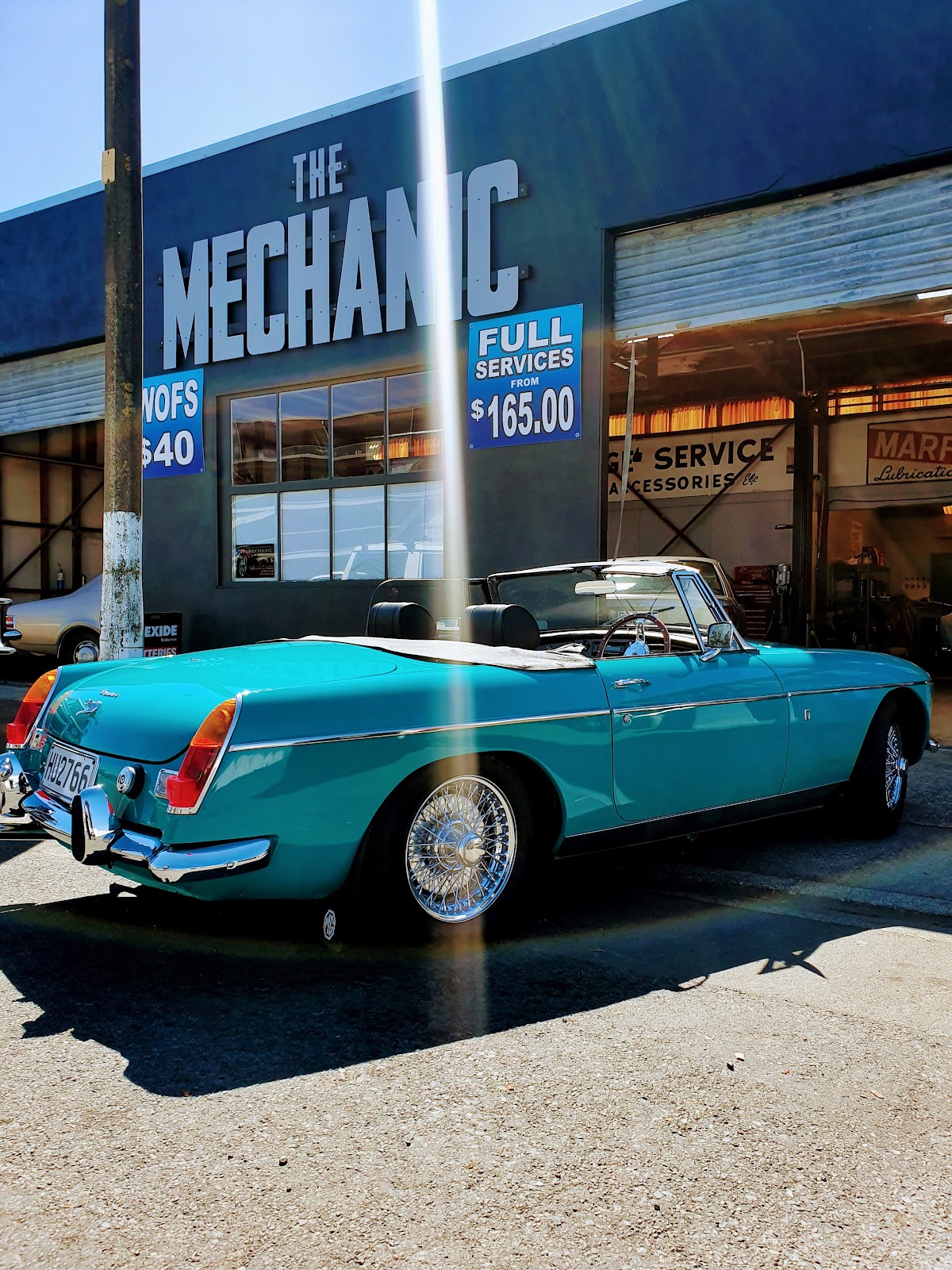 Turquoise MGB roadster outside The Mechanic shopfront